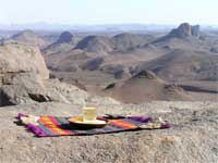 foto de una jarapa con un vaso y plato y las montaas del Hoggar al fondo